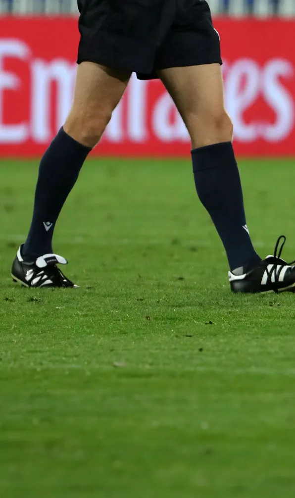Mens Rugby Socks Male rugby player walking across the pitch with his socks pulled up