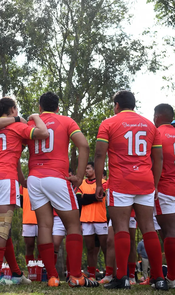 Mens Teamwear A mens rugby team huddles together during a training game