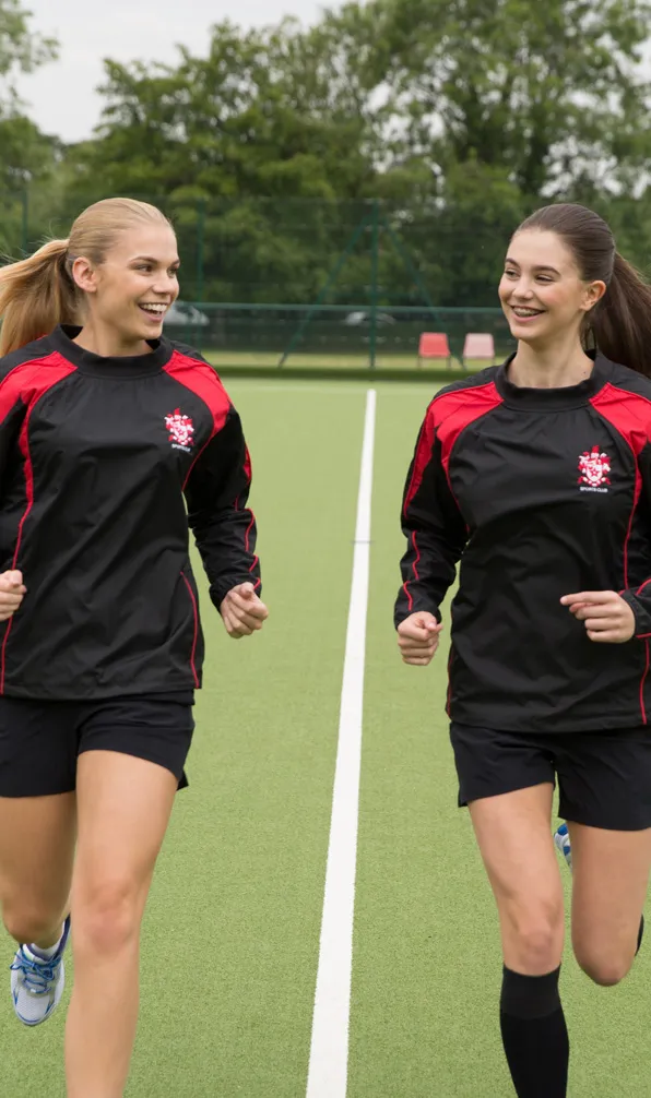 Womens Teamwear Two women enjoying training wearing matching team wear contact tops in black and red