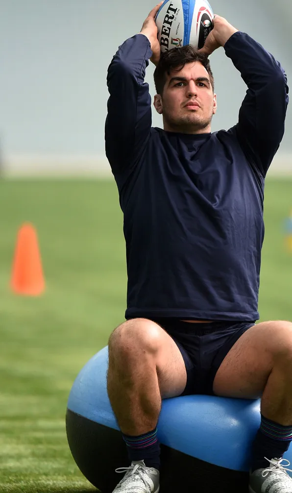 Rugby Training & Fitness Player training with a rugby ball on a gym ball