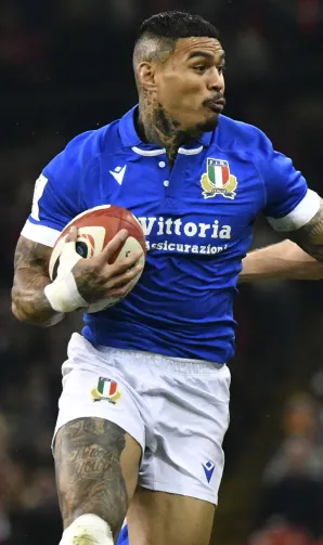 Italy Rugby Sale An Italian rugby player hands away the opposition whilst clutching the ball