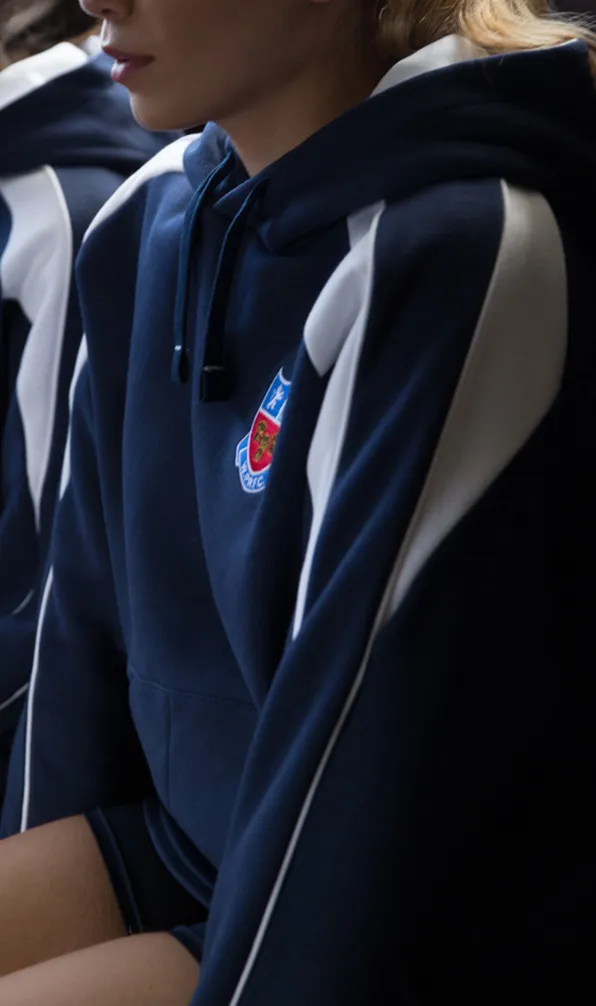Teamwear Hoodies Rugby players sit on the bench in the changing rooms wearing navy and white panelled hoodies with the team logo embroidered on the front