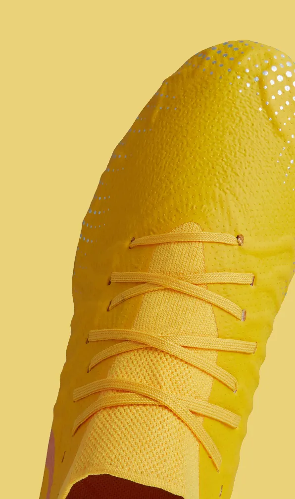 Top view of a Canterbury rugby boot on a yellow background