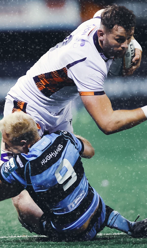 A Cardiff rugby player tackles an Edinburgh rugby player