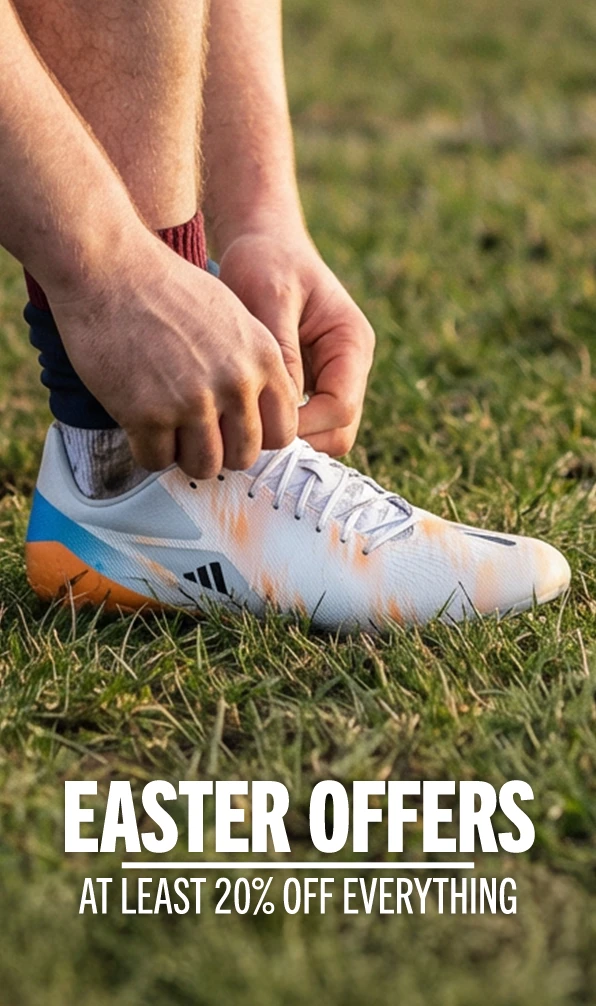A close up image of an Adidas rugby boot, on a rugby pitch, with the lace being tied.