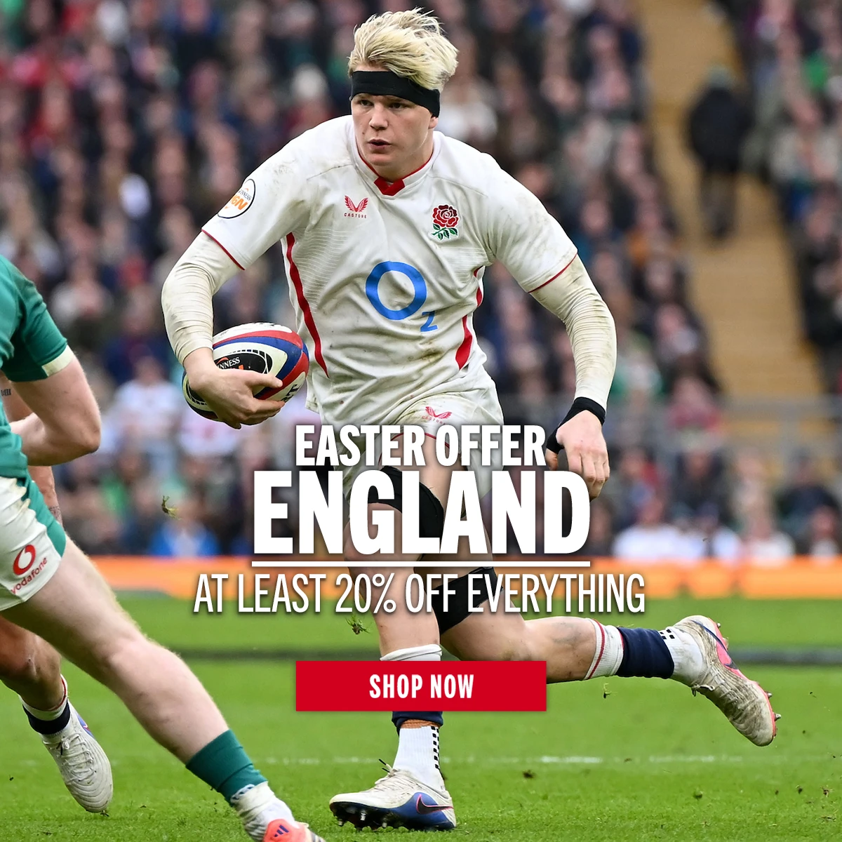Shop England Easter Offers England rugby player Henry Pollock runs holding a rugby ball in his left hand. He is on a rugby pitch in front a large crowd of supporters