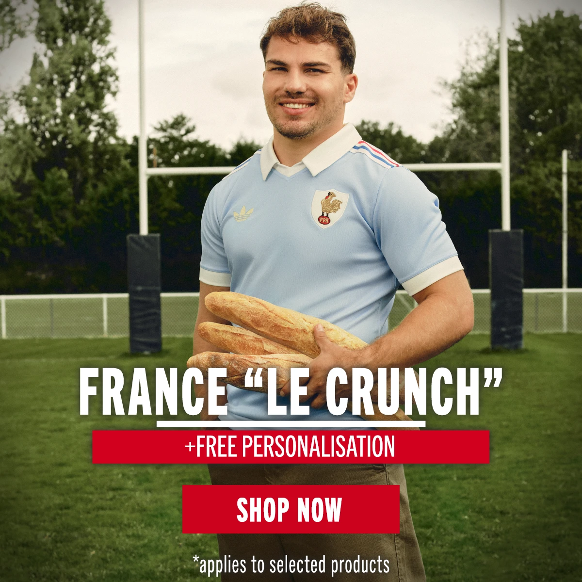 France Le Crunch - Celebrating 120 years of rivalry with England France rugby player Antoine Dupont stands wearing the new rugby shirt from the Adidas France Le Crunch range. He is holding three baguettes.