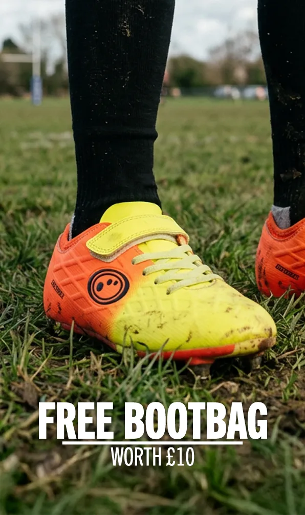 A young player standing on the pitch in their pair of Optimum rugby boots.