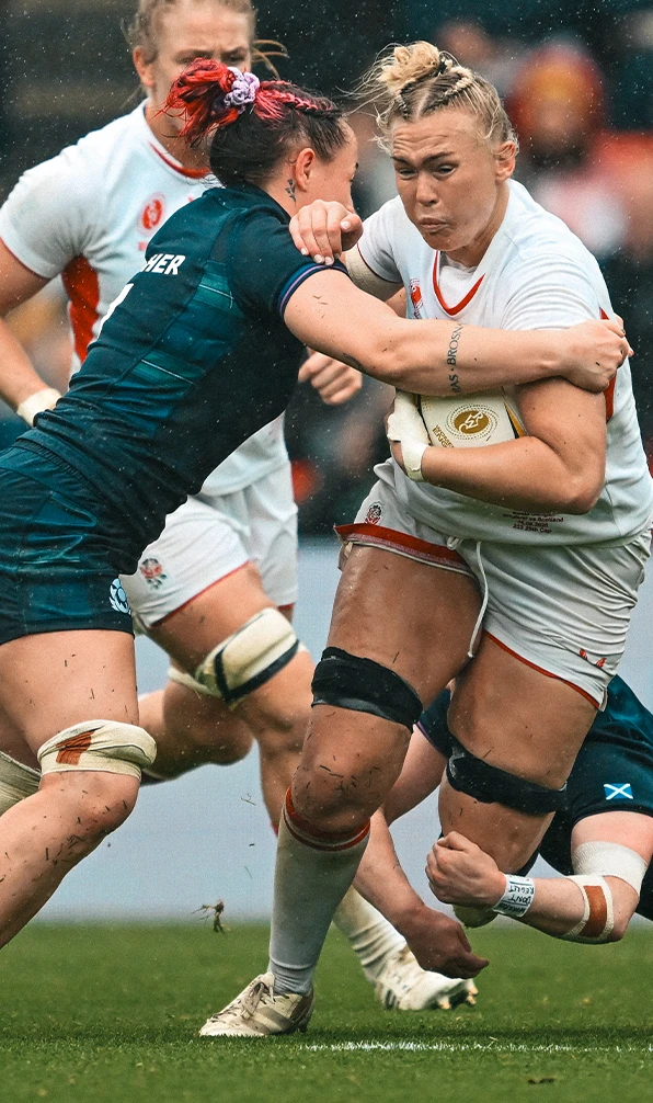 An England Womens Red Roses player is tackled by a Scotland womens player in the Womens 6 Nations tournament.
