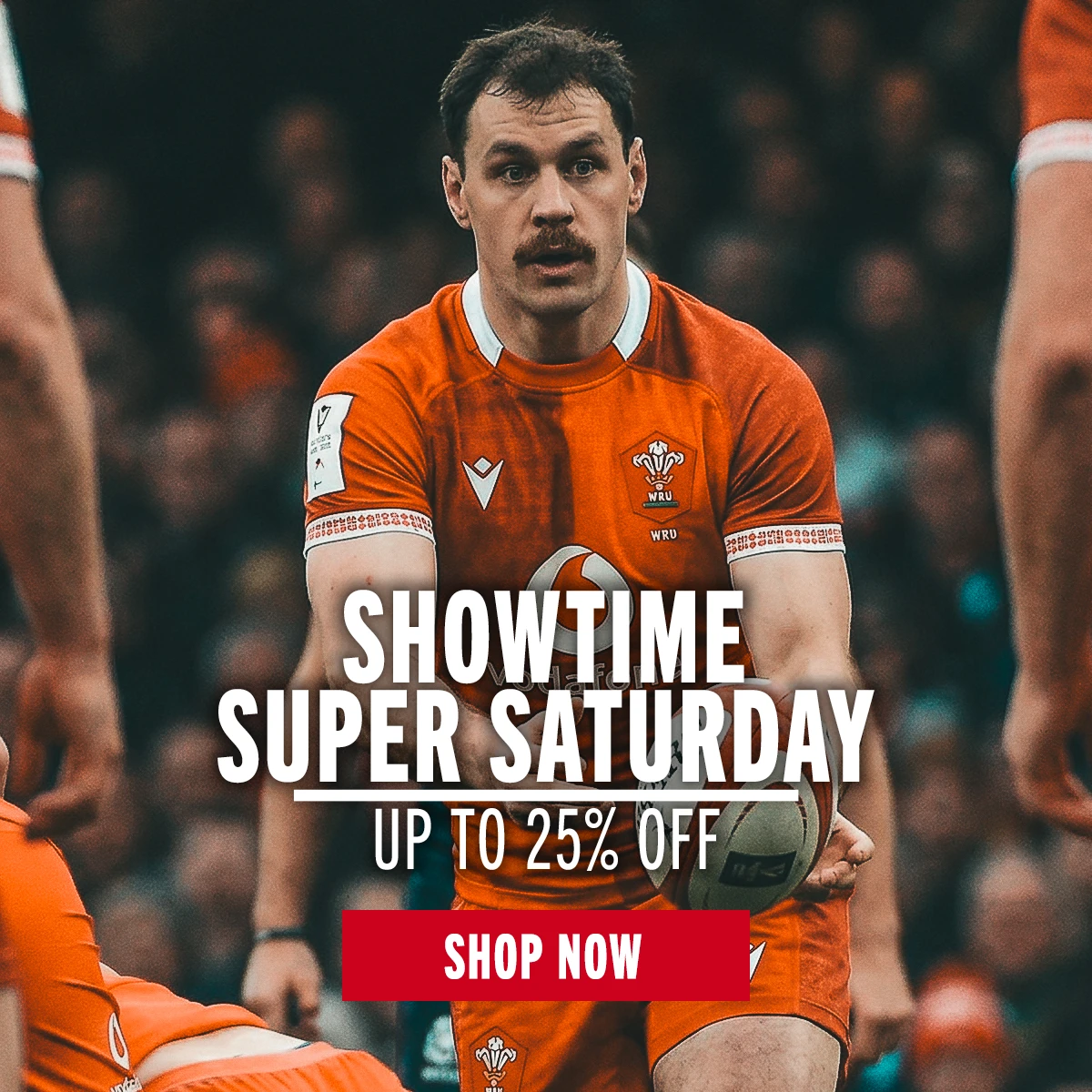 Wales rugby player Tomos Williams passes the ball to a team mate. A large crowd of fans is behind him.