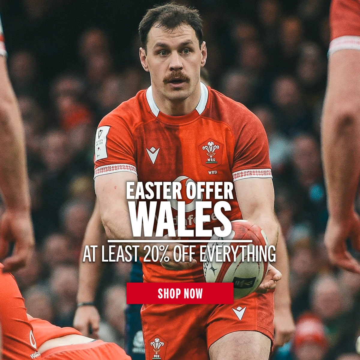 Shop Wales Easter Offers Wales rugby player Tomos Williams passes the ball to a team mate. A large crowd of fans is behind him.