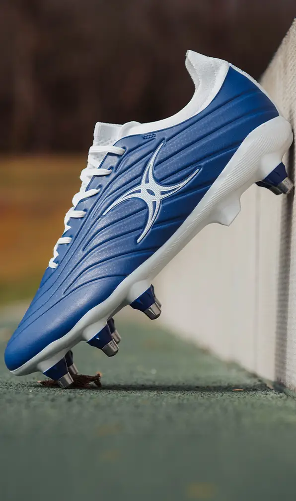A close up image of a Gilbert rugby boots in blue.