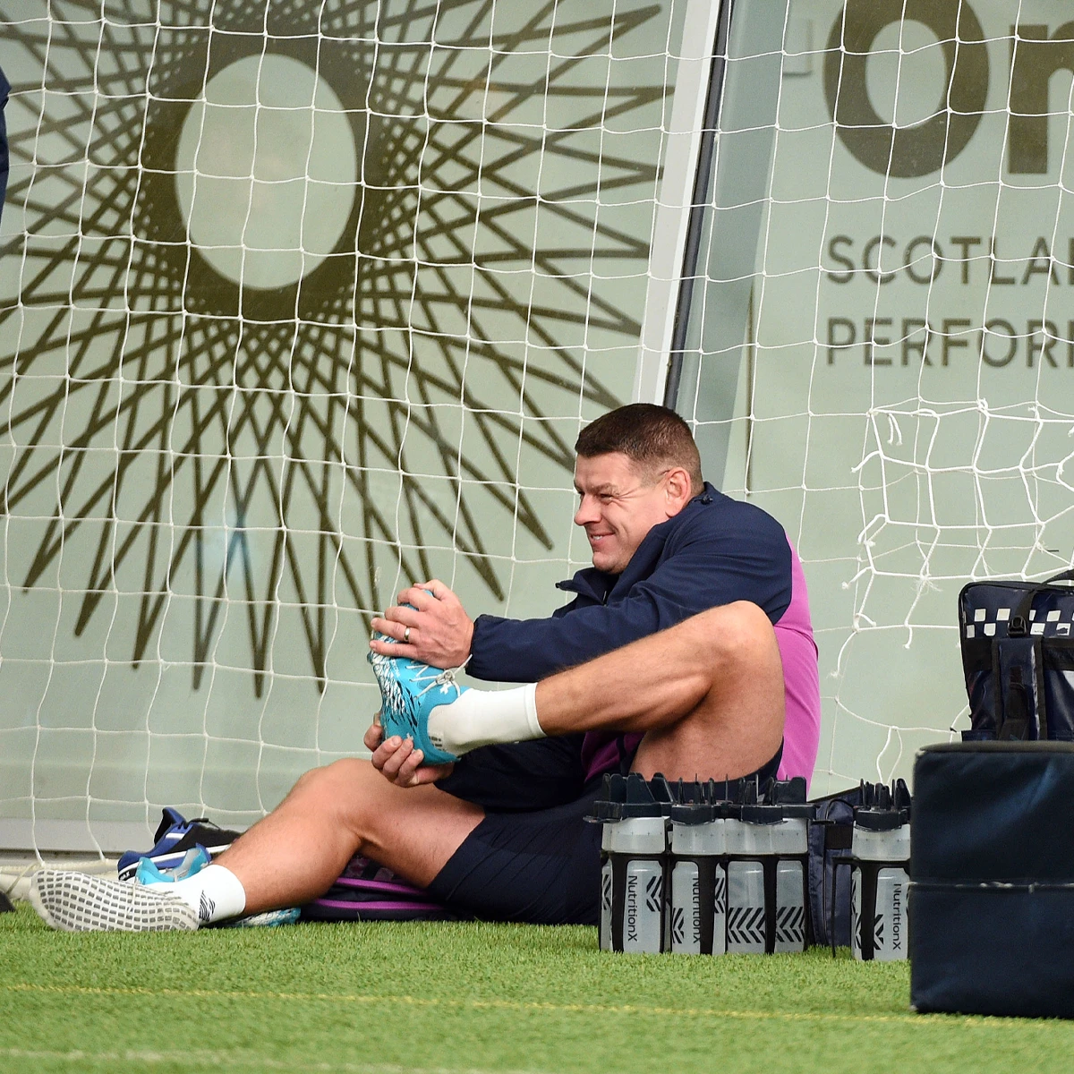 A member of the Scotland coaching staff gets his boots on as he gets ready to lead the session.