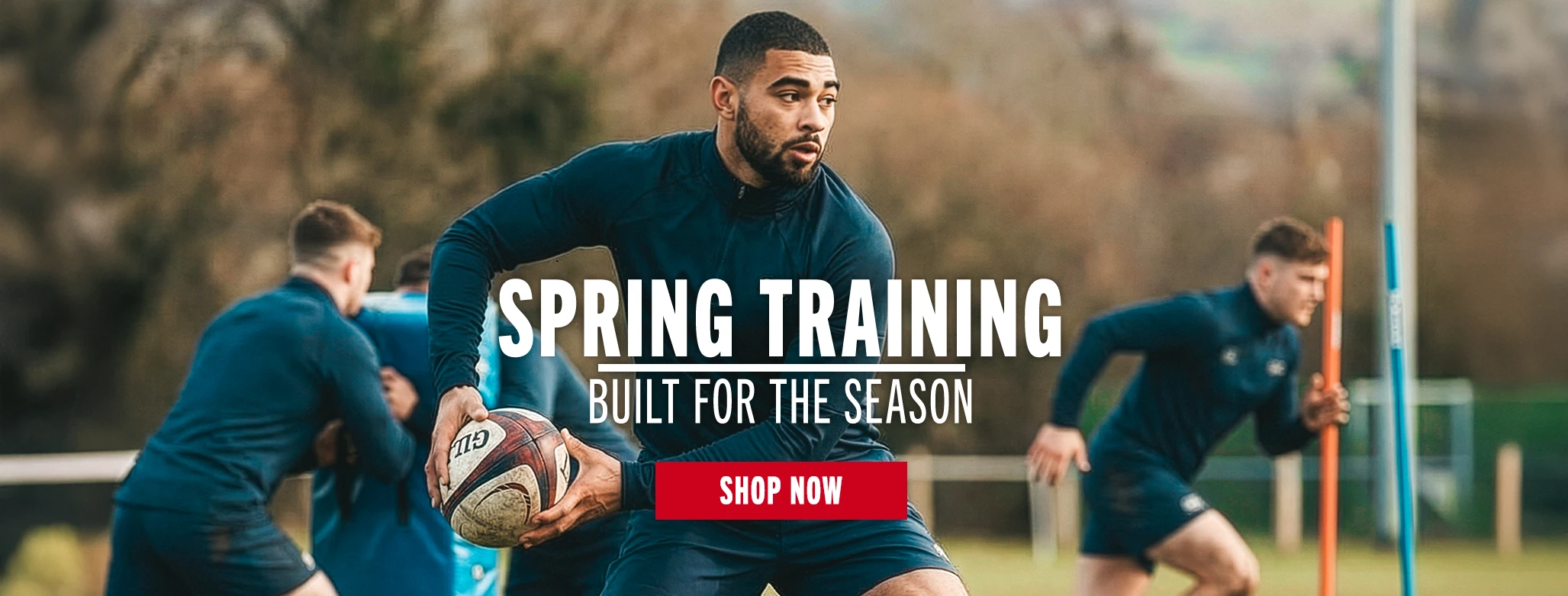 A rugby player dressed in Canterbury training clothing passes a rugby ball. The image has lots of motion.