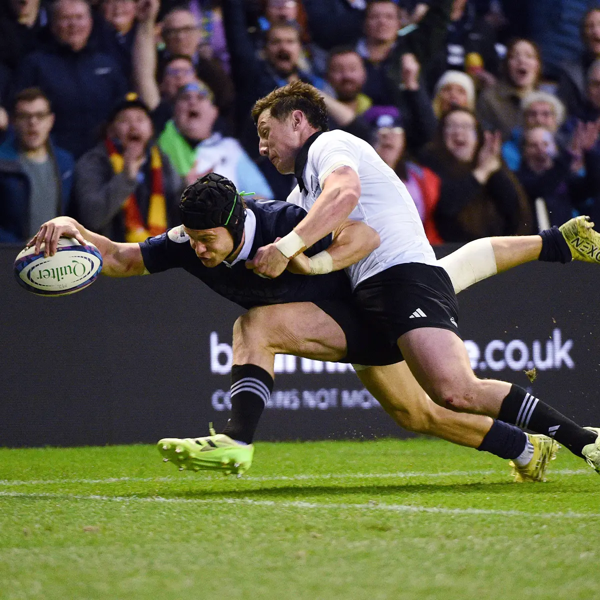 Scotland's Darcy Graham is diving for the try line as he is tackled by an All Blacks defender in their 2025 Autumn Test clash.