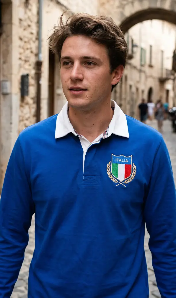 A young man is walking through a Mediterranean town in a Classic Italy rugby shirt.