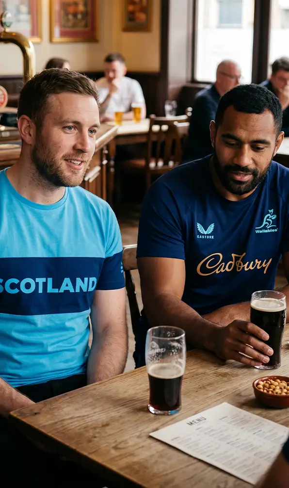 Two guys are at the pub wearing Scotland and Australia t-shirts.
