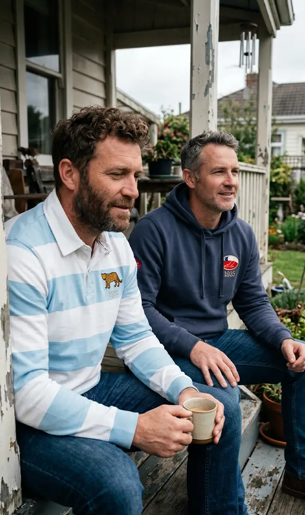Two guys sit on decking outside of a house in Rugby 1823 classic products.