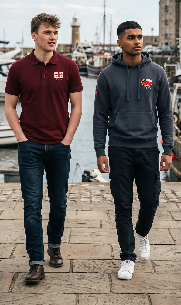 Two young men are walking around the harbour in their Georgia Classic Polo shirt and Chile Classic Hoodie.