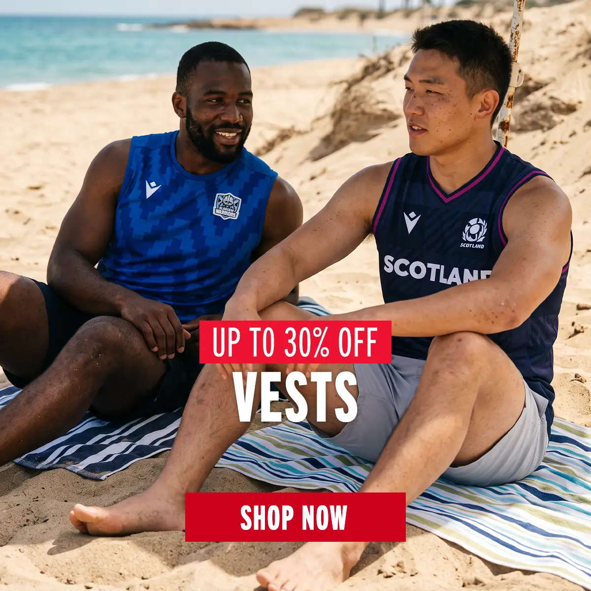 Two guys sit on the beach of in their Glasgow Warriors and Scotland vests.
