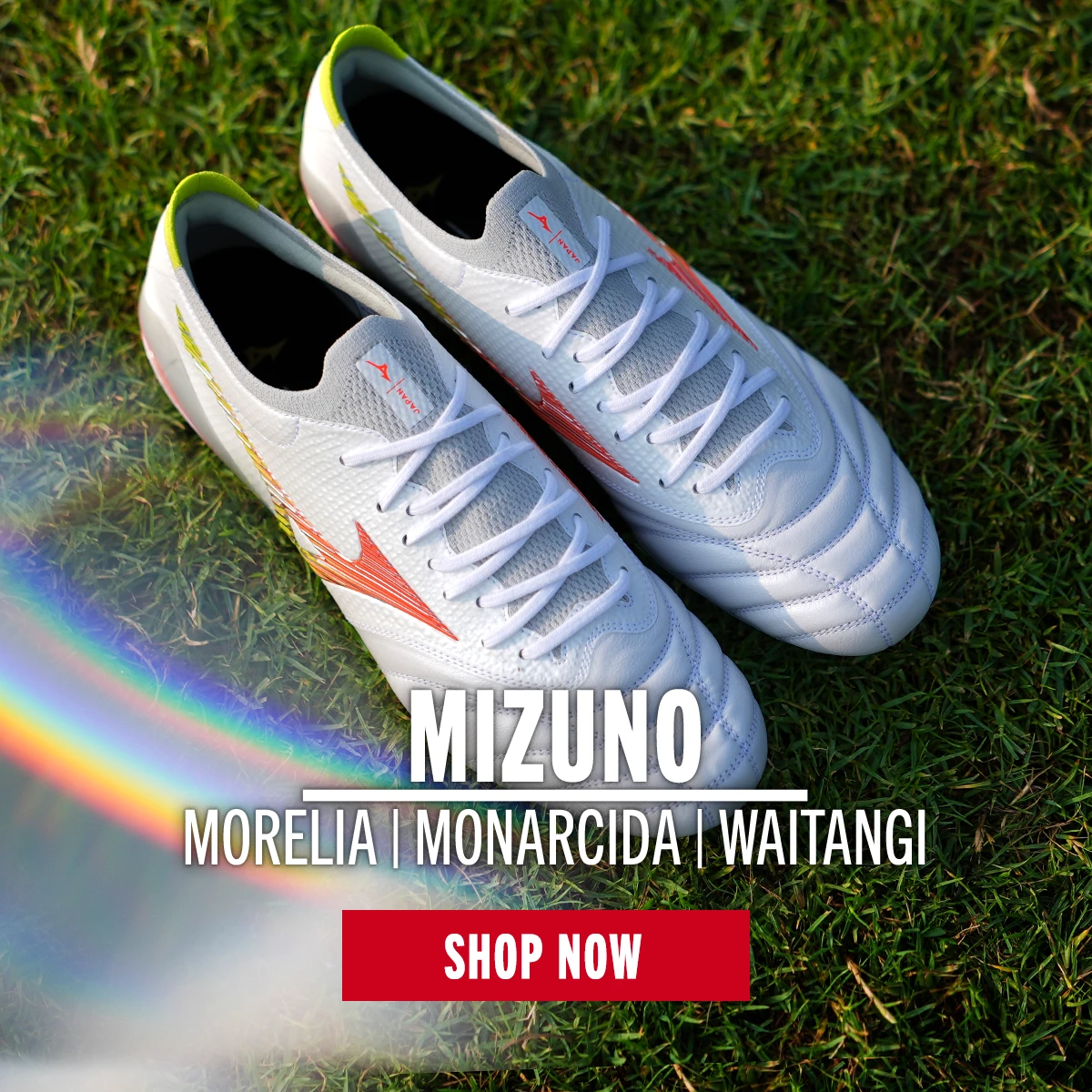 A pair of the Mizuno Prism White boots sit on a rugby pitch.