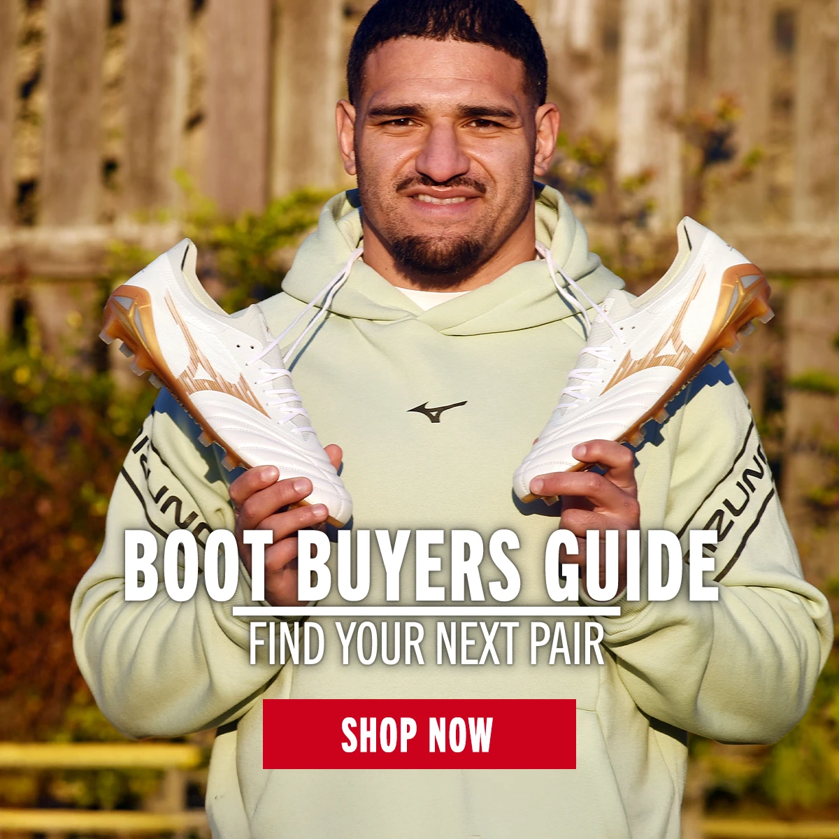 Boot Buyers Guide Sione Tuipulotu stands holding Mizuno boots.