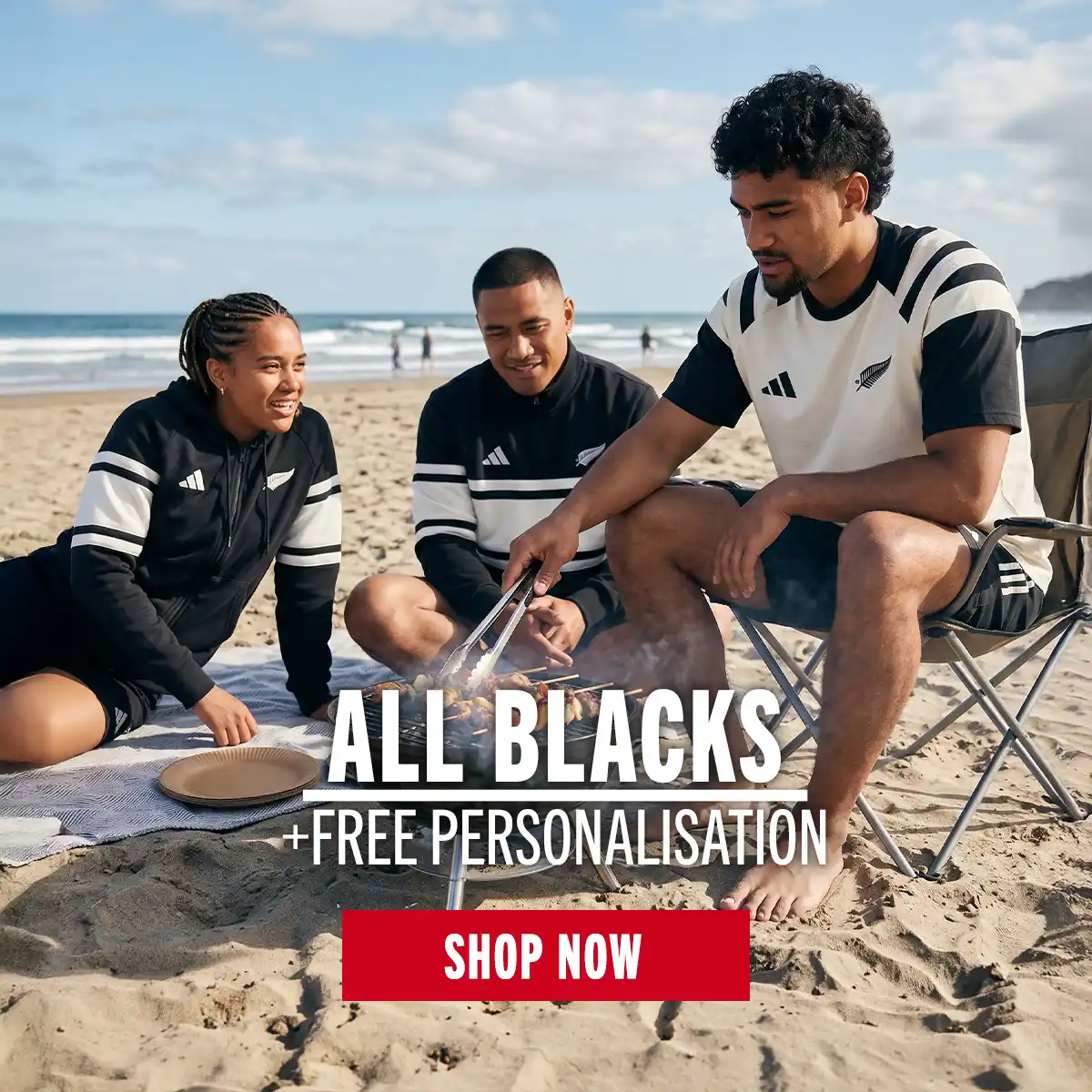 Three people are chilling on a beach wearing the new All Blacks Leisure as they enjoy the heat.