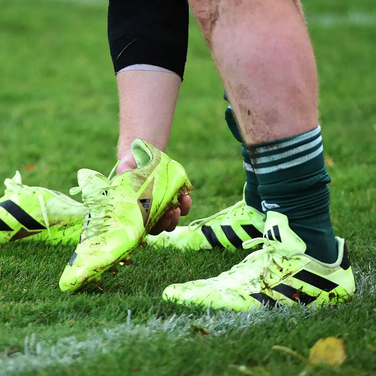 Rugby Boot Fit Guide Photo 2 A player at the All Blacks Training Camp in Scotland is picking up his Adidas rugby boots.